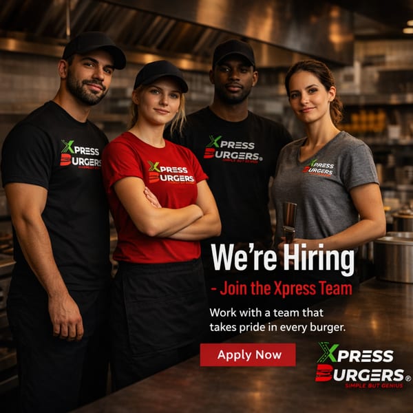 Four smiling Xpress Burgers employees in uniform stand in a restaurant kitchen, advertising job openings.