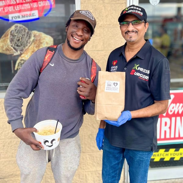 Two men smiling, one holding a noodle cup and the other a burger bag from Xpress Burgers.